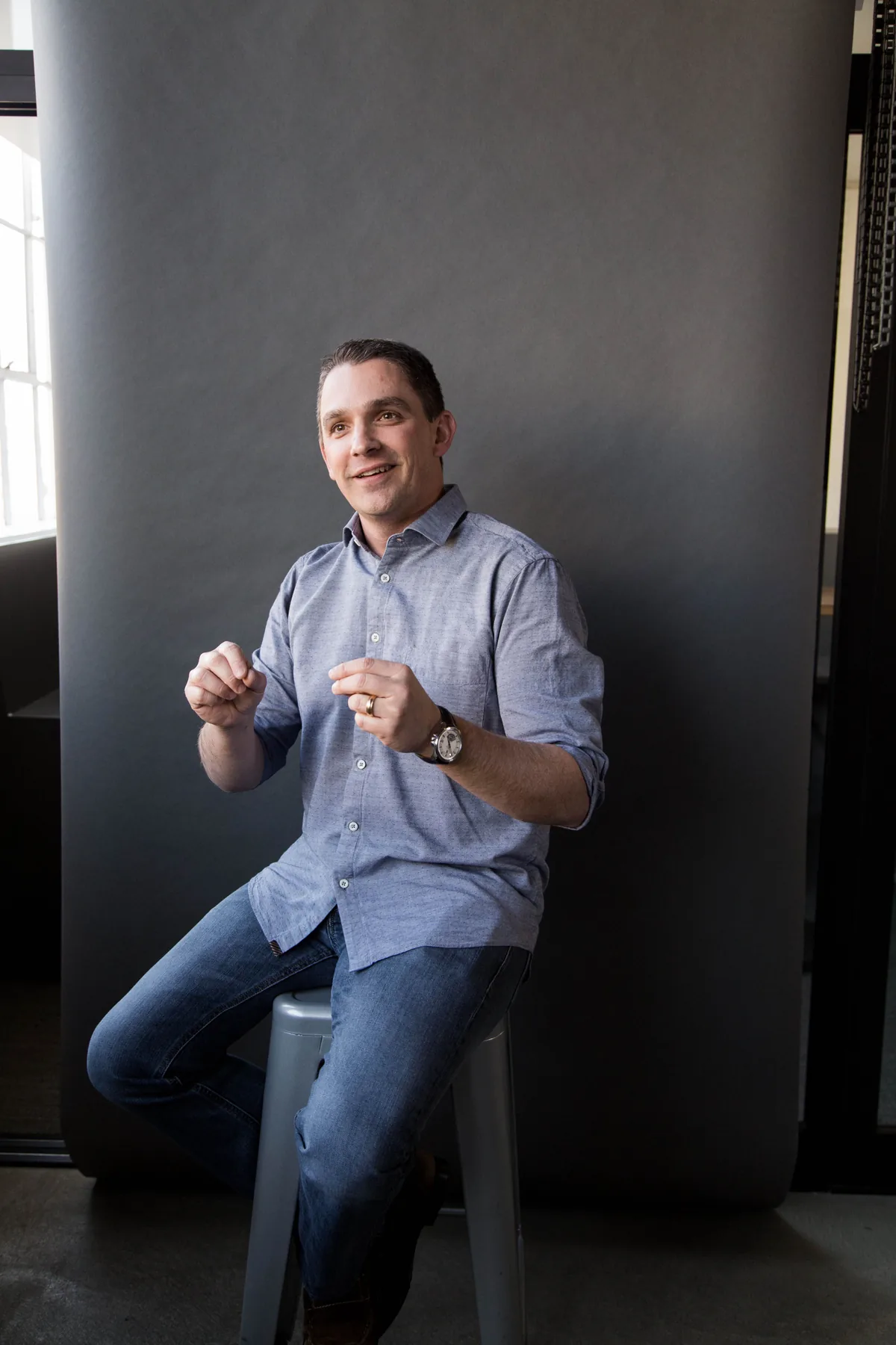 Ryan Deiss seated on a stool mid-conversation, gesturing
